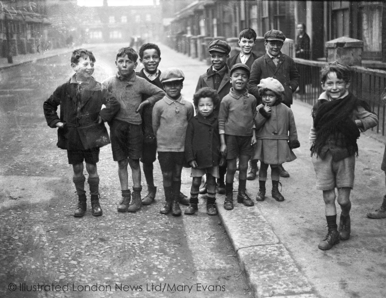 CHILDREN ON A STREET Black and white photograph of a multiracial children on a terraced street circa 1930s.
