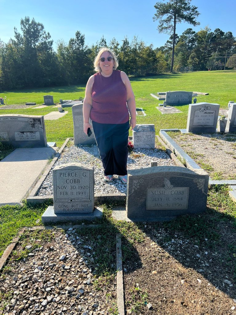 Photo of Bec Matthews standing by two graves