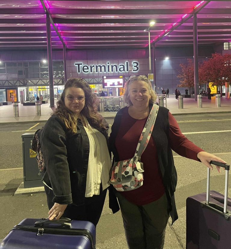 Bec and Esther Matthews standing outside Terminal 3 at the airport with their suitacases
