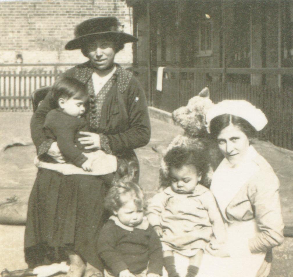 Image: Rachael’s great-grandmother Ethel (in uniform on the right) holding a child in her lap at the Woolwich Nursery for the Children of Munition Workers, c.1919. Image © Rachael Grant at The Mixed Museum / Courtesy of Rachael Grant