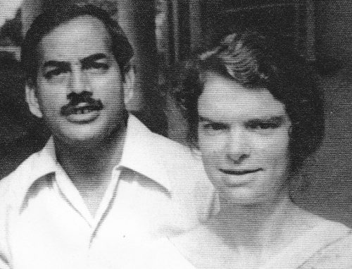Black and white portrait photograph of Sultan Shariff standing beside Nora Shariff. They appear to be in their early 20s. Sultan wears a light shirt and has a moustache; Nora has short, wavy hair.