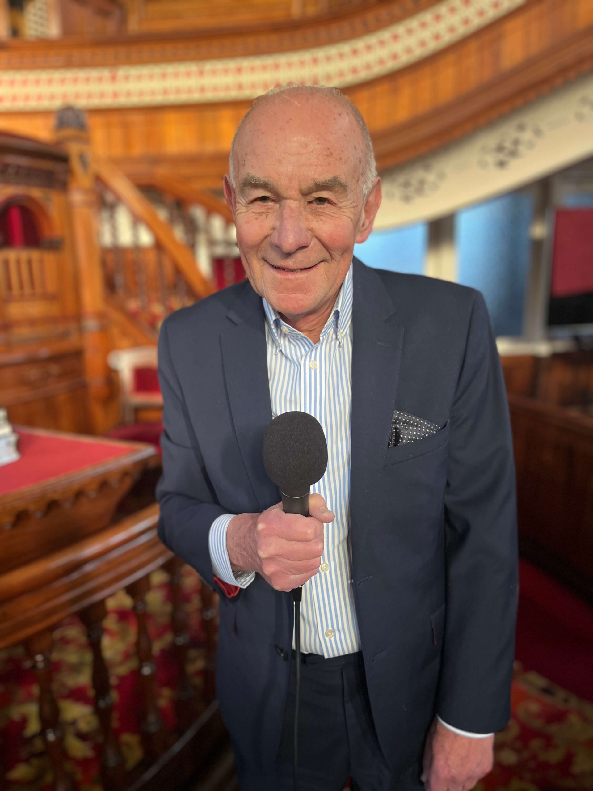 Huw Tregellis Williams holding a microphone inside the Tabernacle Chapel, Swansea
