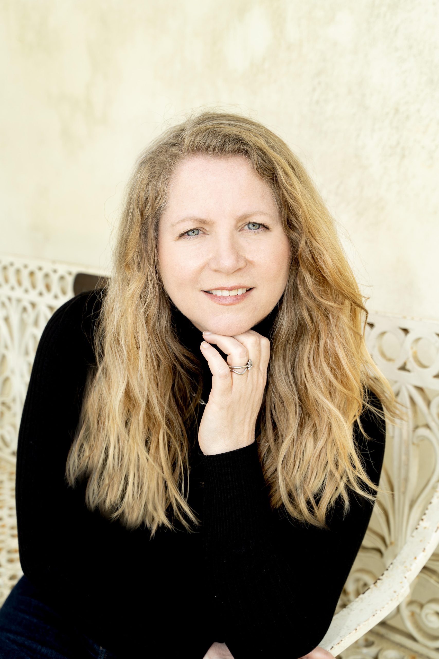 Susan Alexander headshot October 2025 Headshot of photographer Susan Alexander wearing a black longsleeved top. She has long blonde hair and is resting her hand on her chin as she poses for the camera.